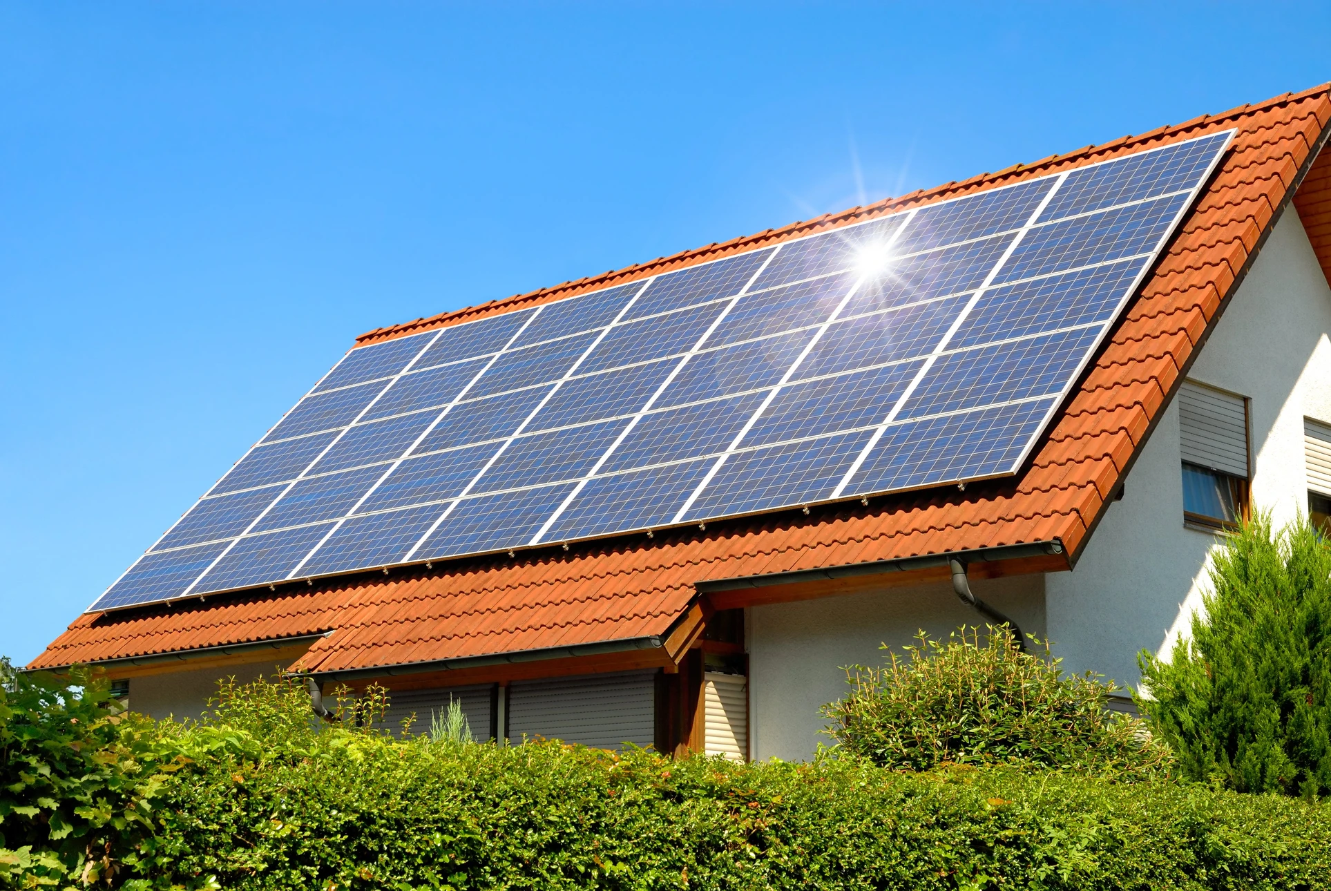 Maison résidentielle avec installation de panneaux solaires photovoltaïques sur toiture en tuiles terre cuite