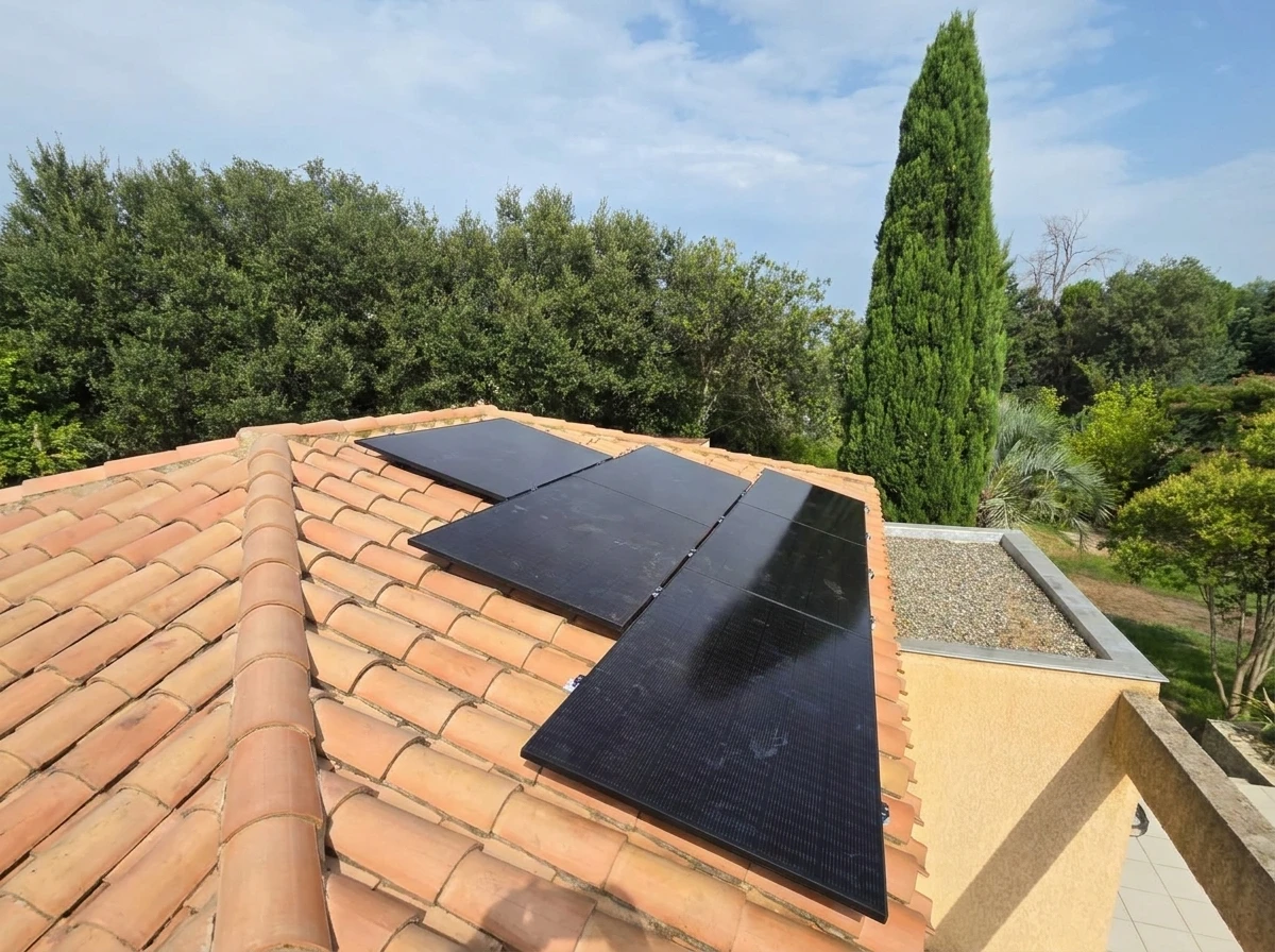 Toiture résidentielle équipée de panneaux solaires photovoltaïques installés sur tuiles en terre cuite ondulées